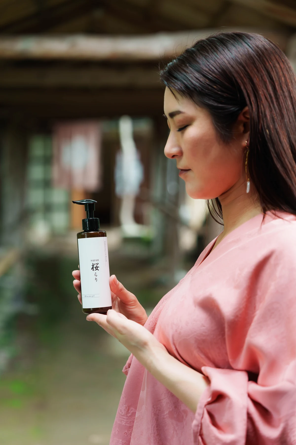 木々に囲まれた場所で桜らりをそっと手にする女性